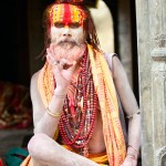 KATHMANDU, NEPAL - MAY 04: Holy Sadhu man with beard and traditional face paint sitting in Pashupatinath Temple on May 04, 2014 in Nepal, Kathmandu.